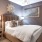 Furnished bedroom with a bed and side table and high ceilings in homes at Flats at Ponce City Market